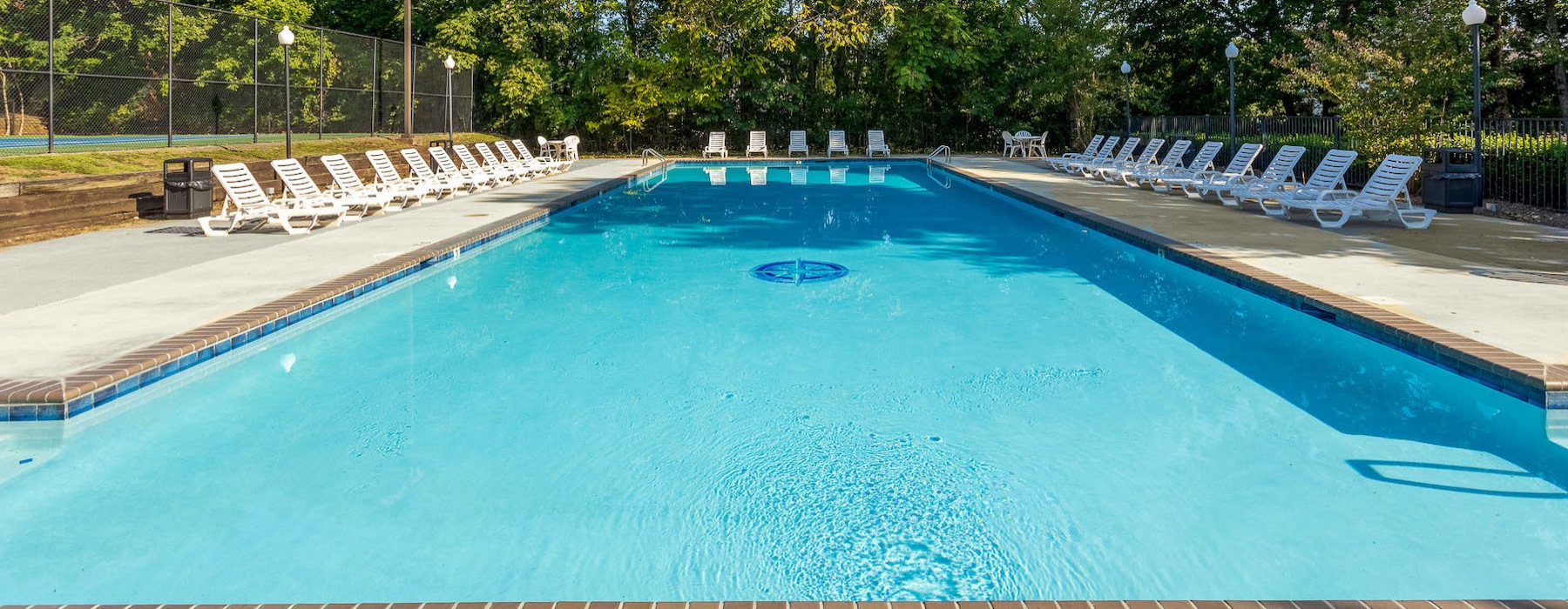 Large sparkling pool with large pool deck and lounge chairs