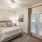 Large well lit bedroom with plush carpets and large windows 