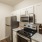 Spacious and well lit kitchen with wood flooring and stainless steel appliances