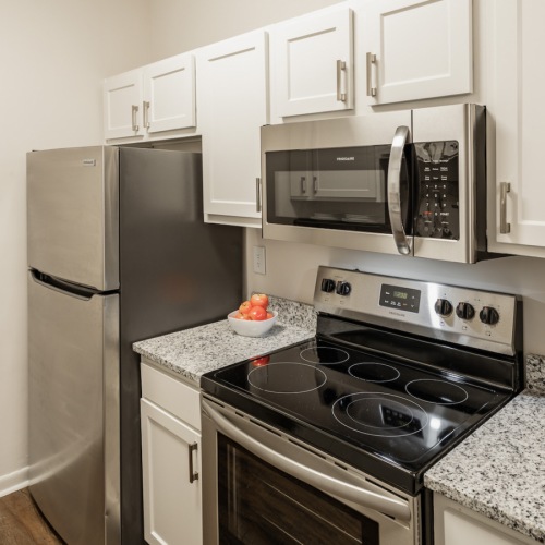 Kitchen Spacious and well lit kitchen with wood flooring and stainless steel appliances