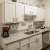 Spacious and well lit kitchen with wood flooring and stainless steel appliances