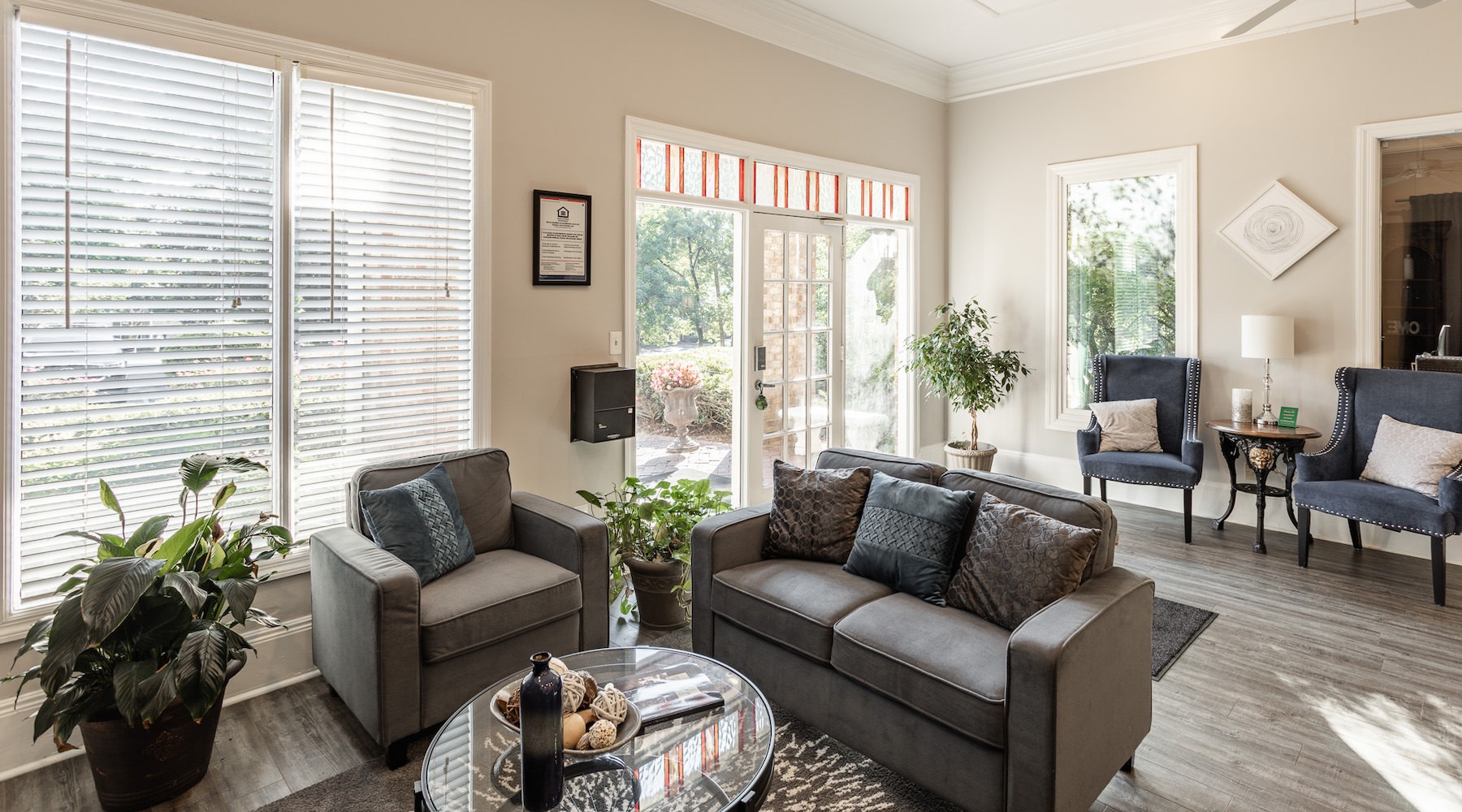 Spacious well lit lounge area with seating and a large tv