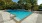 Large sparkling blue pool with a large pool deck and lounge chairs